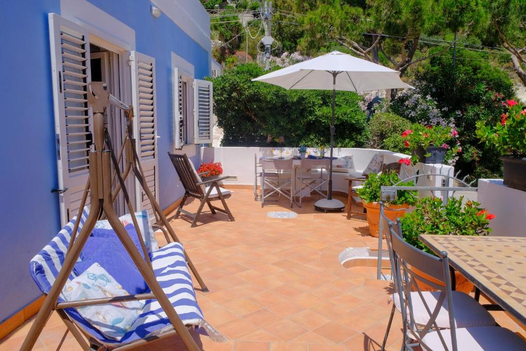 eine Terrasse mit Tisch und Sonnenschirm in der Unterkunft L'Oleandro Bianco in Ponza