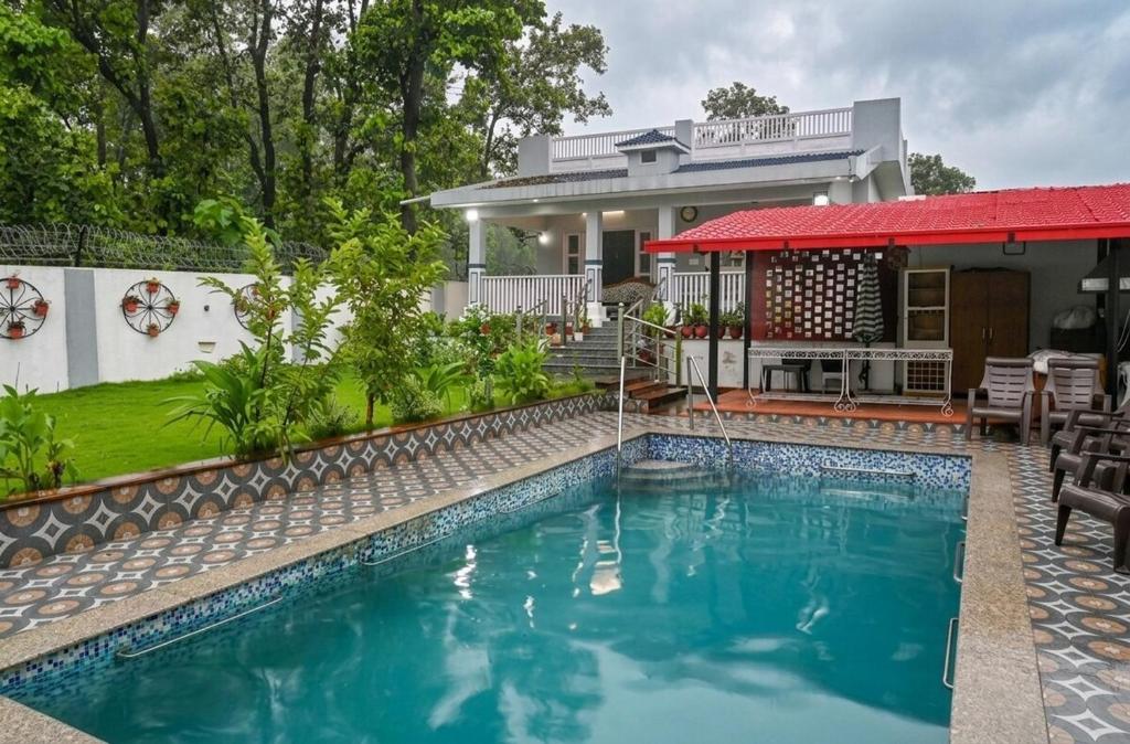a swimming pool in front of a house at Kudrat Villa with Private Pool in Dehradun