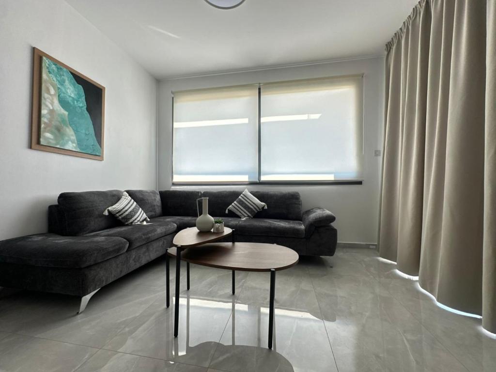 a living room with a couch and a table at Flamingo Vacation Rentals in Paphos