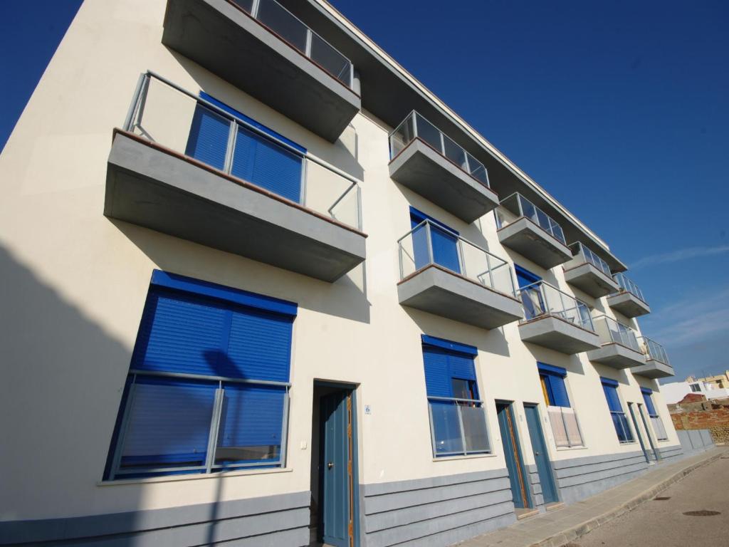 un edificio bianco con finestre blu e una porta di Livingtarifa Apartamento Blue I a Tarifa