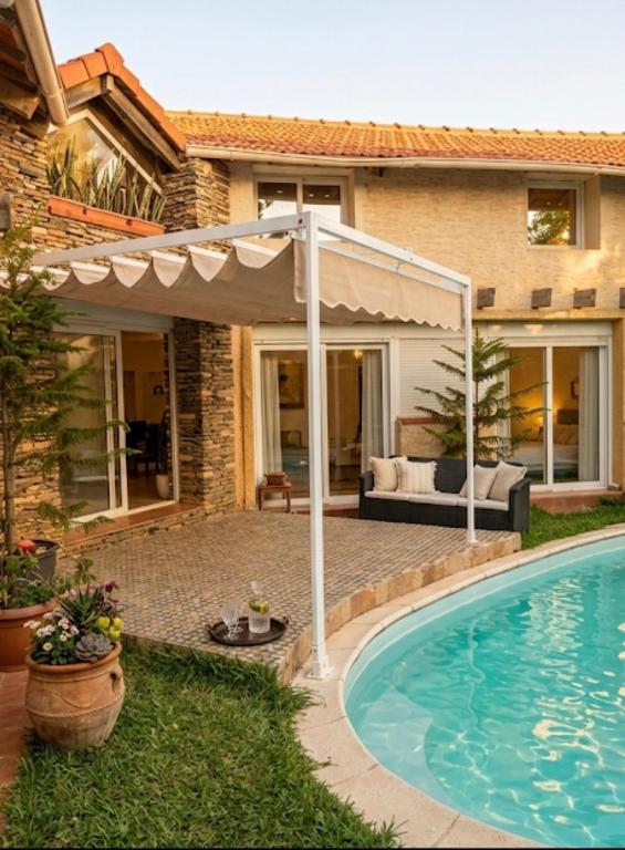 a pergola and a swimming pool in front of a house at Villa Samia in Staoueli