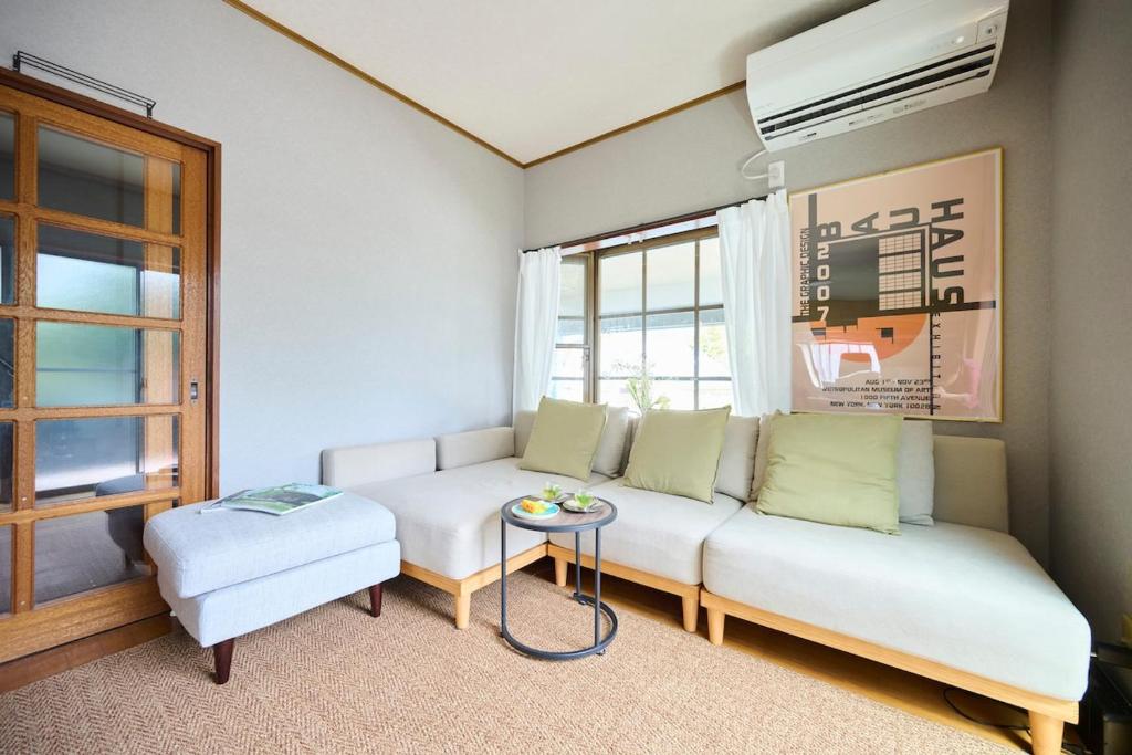 a living room with a white couch and a table at Miura Base in Miura