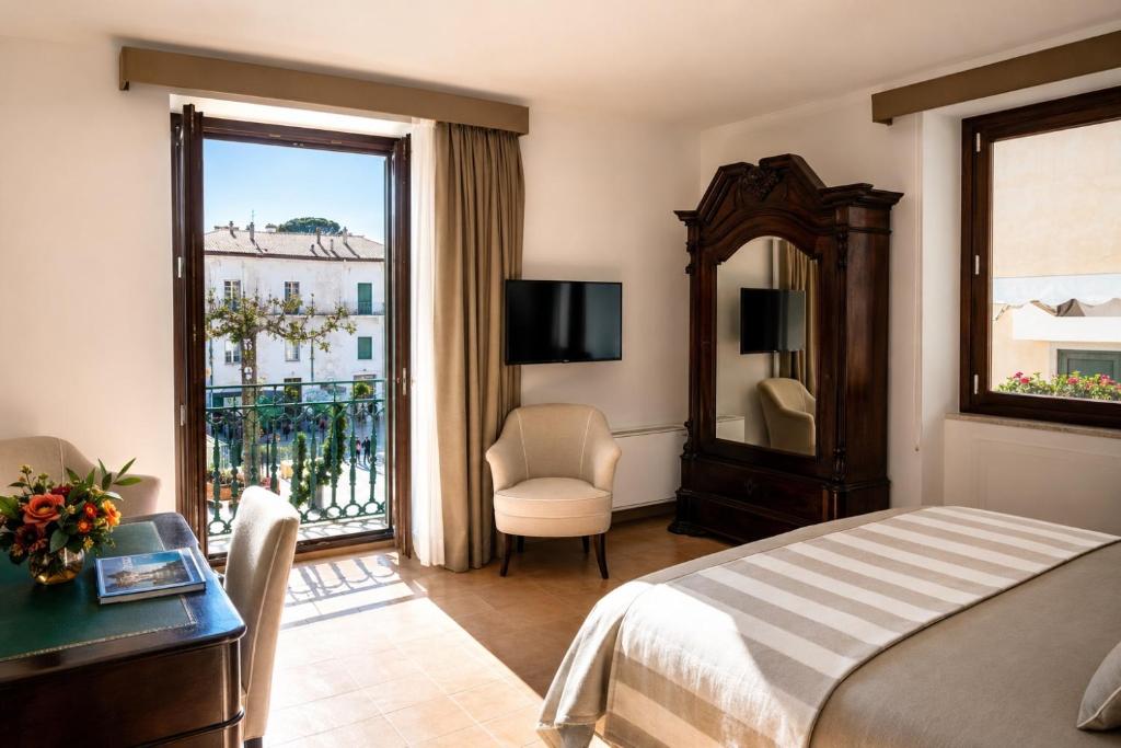 a hotel room with a bed and a large window at Giardini Calce - Luxury Rooms in Ravello