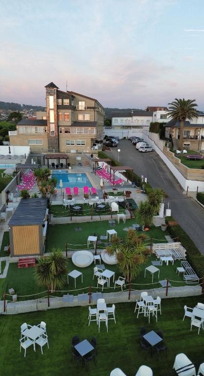 Luftaufnahme eines Resorts mit Tischen und einem Pool in der Unterkunft Hotel Marola in A Lanzada
