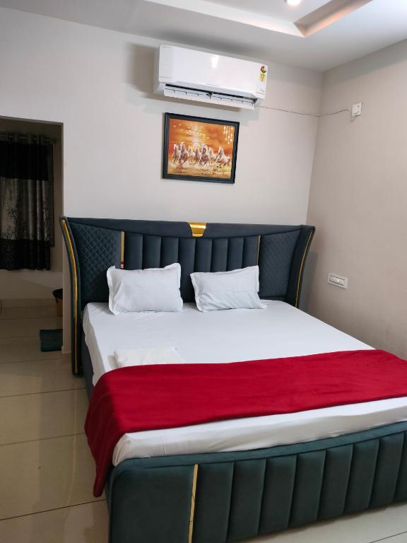 a bed in a room with a red blanket at Royal Residency in Vākalapūdi