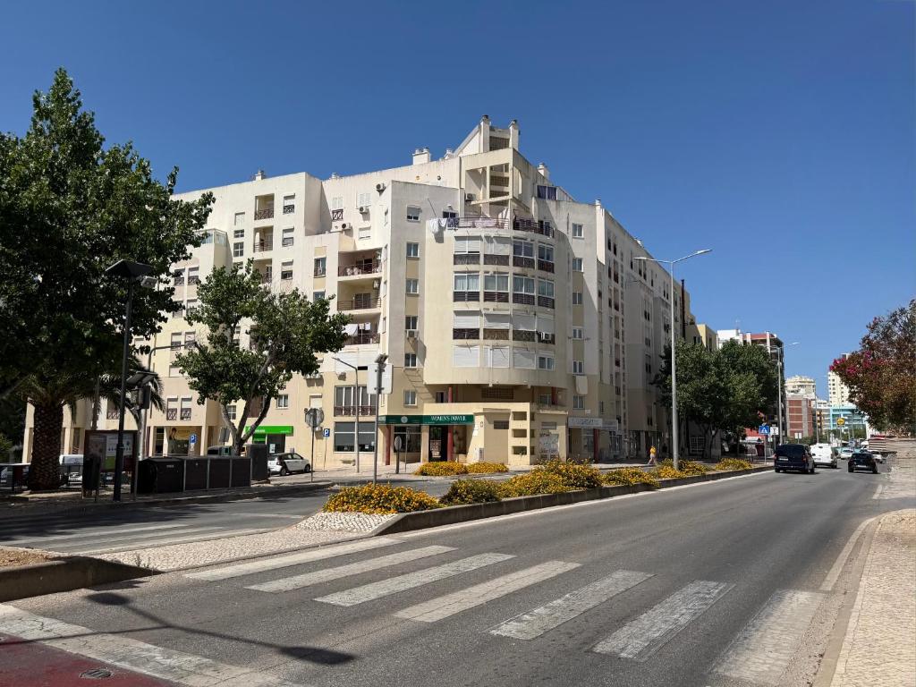 a large white building on the side of a street at Edificio Nau B in Armação de Pêra