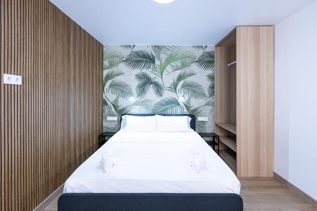 a bedroom with a large bed with a tropical wallpaper at YES! Rooms in Alicante