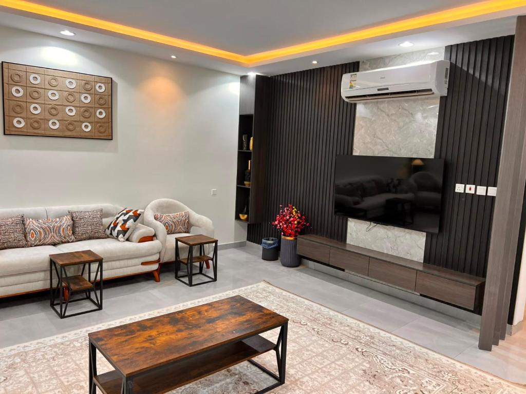 a living room with a couch and a tv at تلال الفخامة in Hail