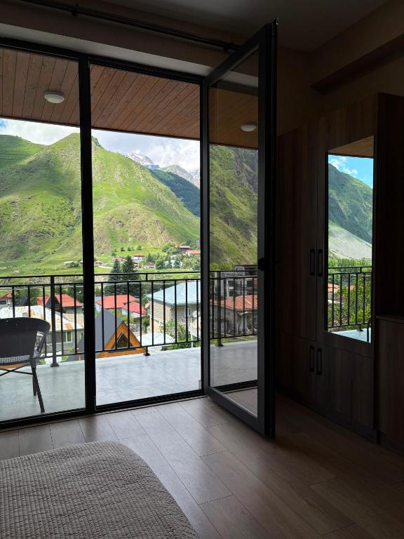 a room with a view of a mountain through glass doors at Hotel Sweet Night in Kazbegi