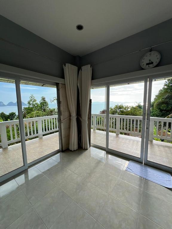 a living room with large windows and a balcony at The Sunset Suite Panoramic Sea Views in Sikao