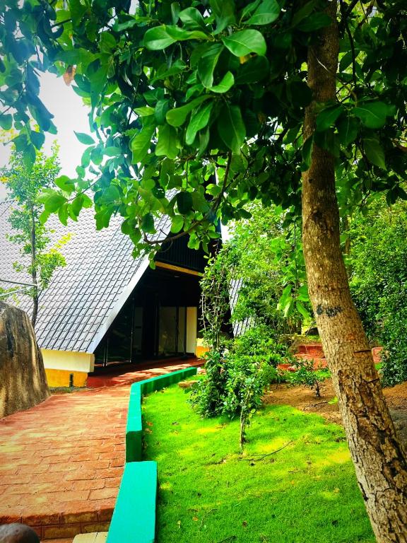 a green bench in front of a building at Dambulla Tiger Rock Hotel with Mountain Viewpoint in Dambulla