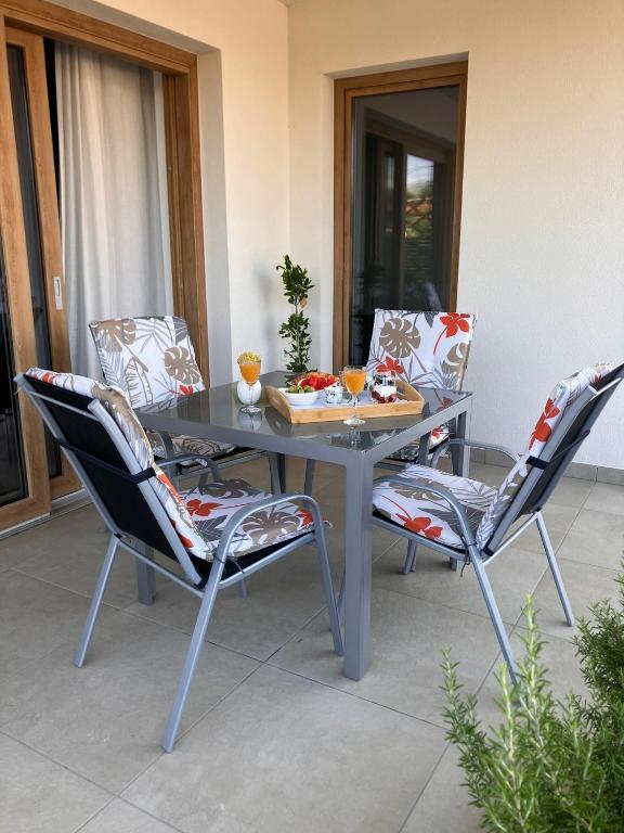 ein Tisch und vier Stühle mit einem Tablett mit Essen darauf in der Unterkunft Apartment Oblica-beautiful new, well equipped apartment in Kastav