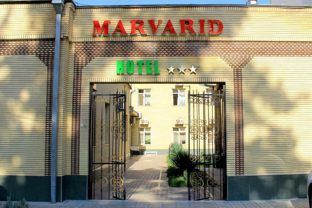 a building with the entrance to a hotel with a sign at Marvarid INN in Samarkand