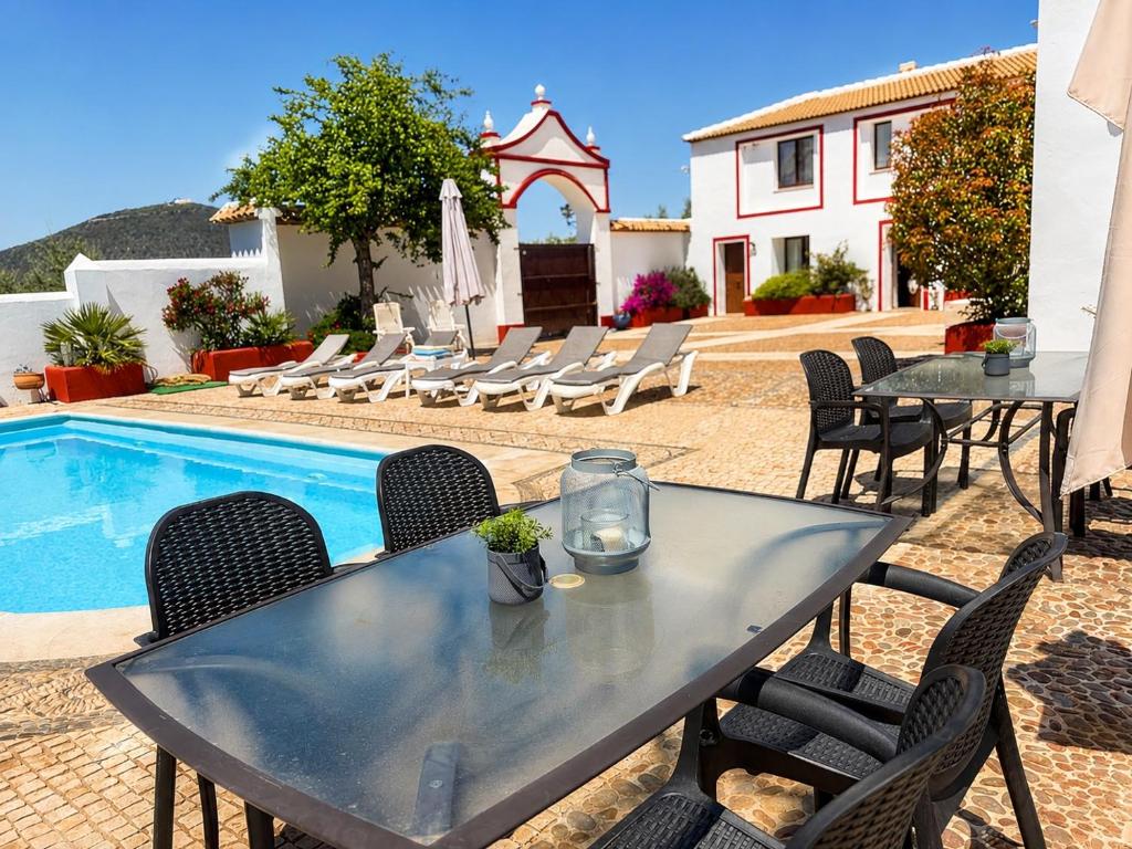 a table and chairs next to a swimming pool at Cortijo Domínguez - Rural Experience in Lucena