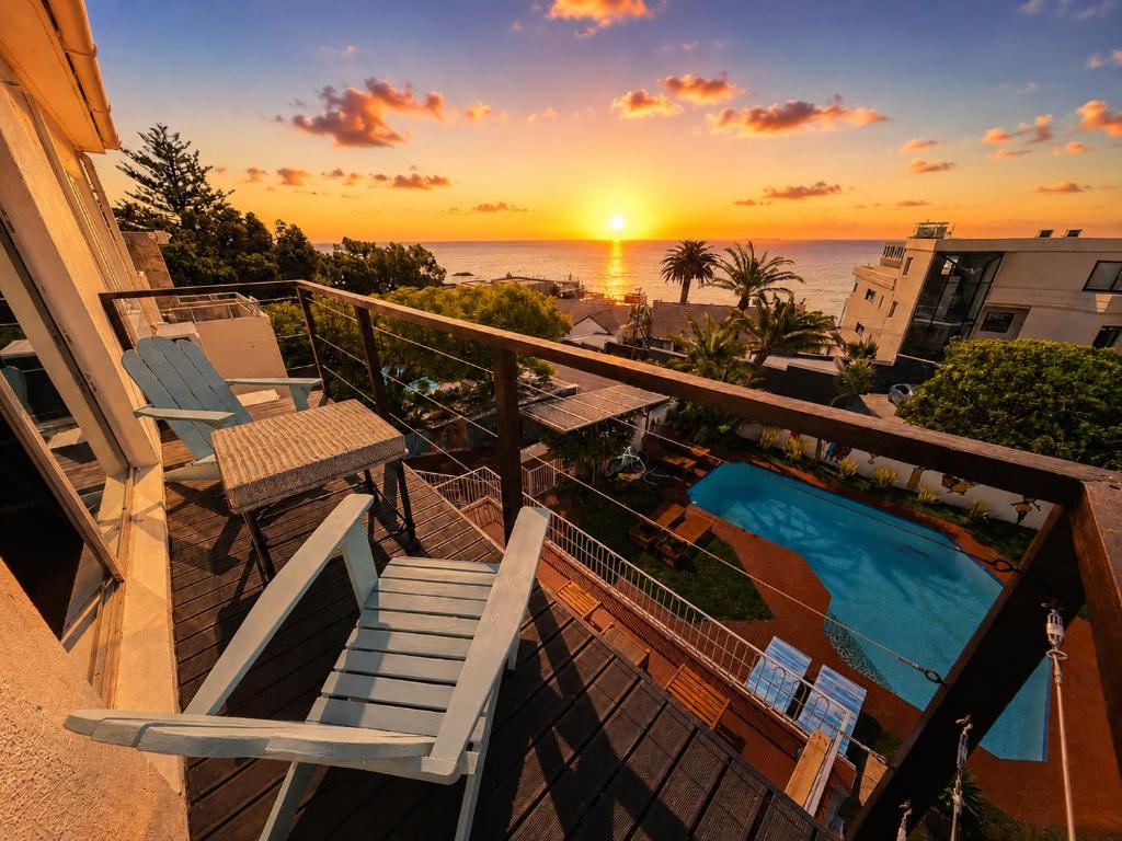 a balcony with a view of a swimming pool and the ocean at SeaViu Camps Bay in Cape Town