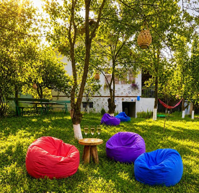 four colorful bean bags in the grass next to a tree at Villa Bubi in Tbisi