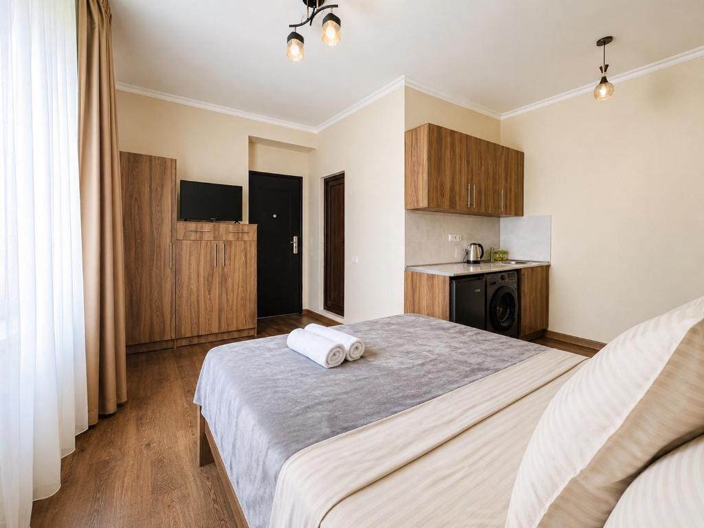 a bedroom with a large bed with two towels on it at Due apartments in Borjomi