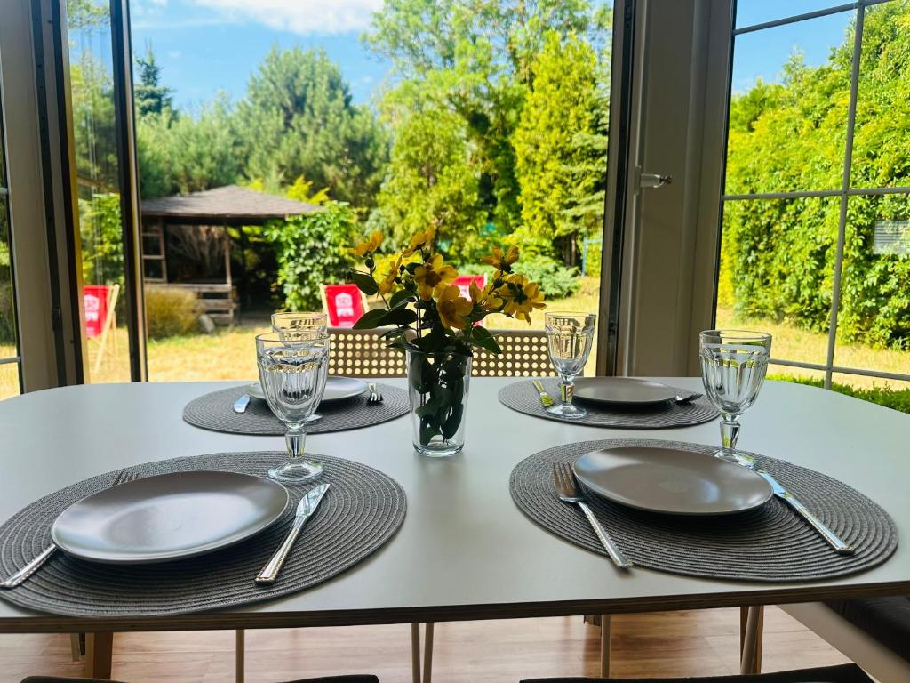 a white table with plates and silverware on it at Dom w Niechorzu dla 8 osób z dużym ogrodem - 5D Apartments in Niechorze
