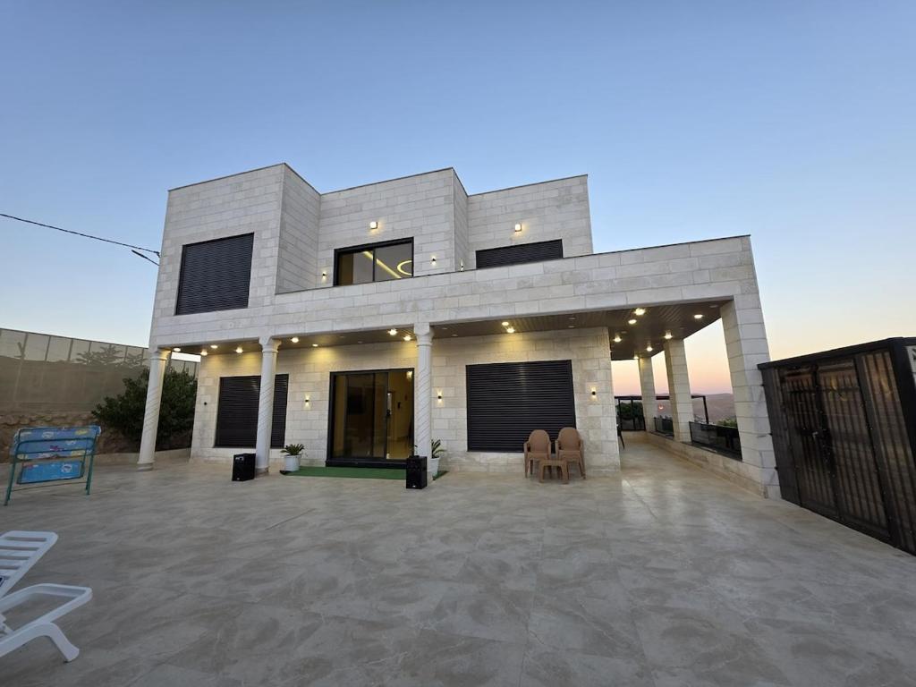 a house with a large patio in front of it at Ayla Shalet Villa in Al Kufayr