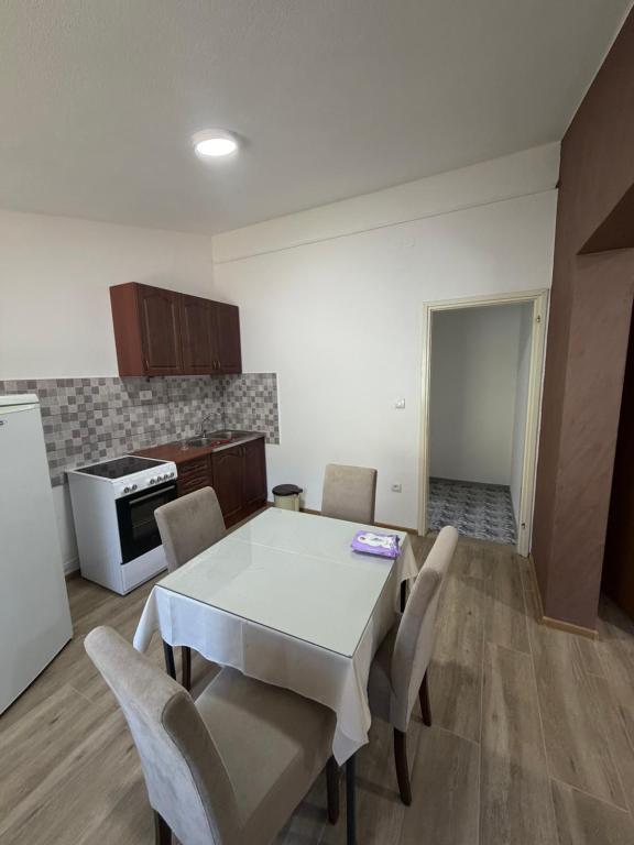 a kitchen with a table and chairs in a room at Apartman Sambi 3 in Čanj