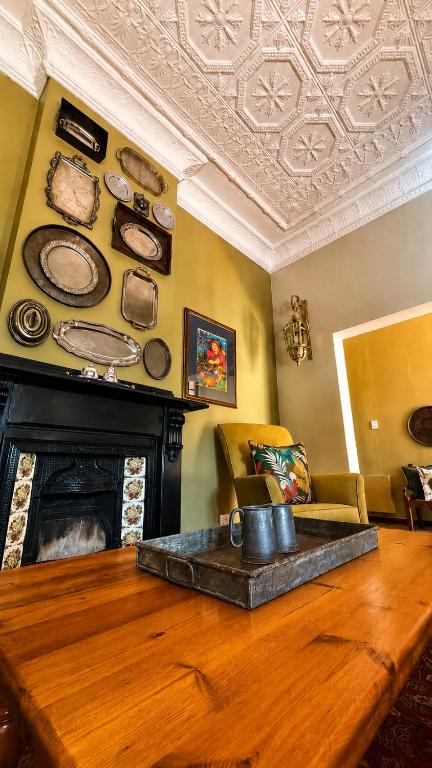 a living room with a table and a fireplace at Del Roza Guest House in Middelburg