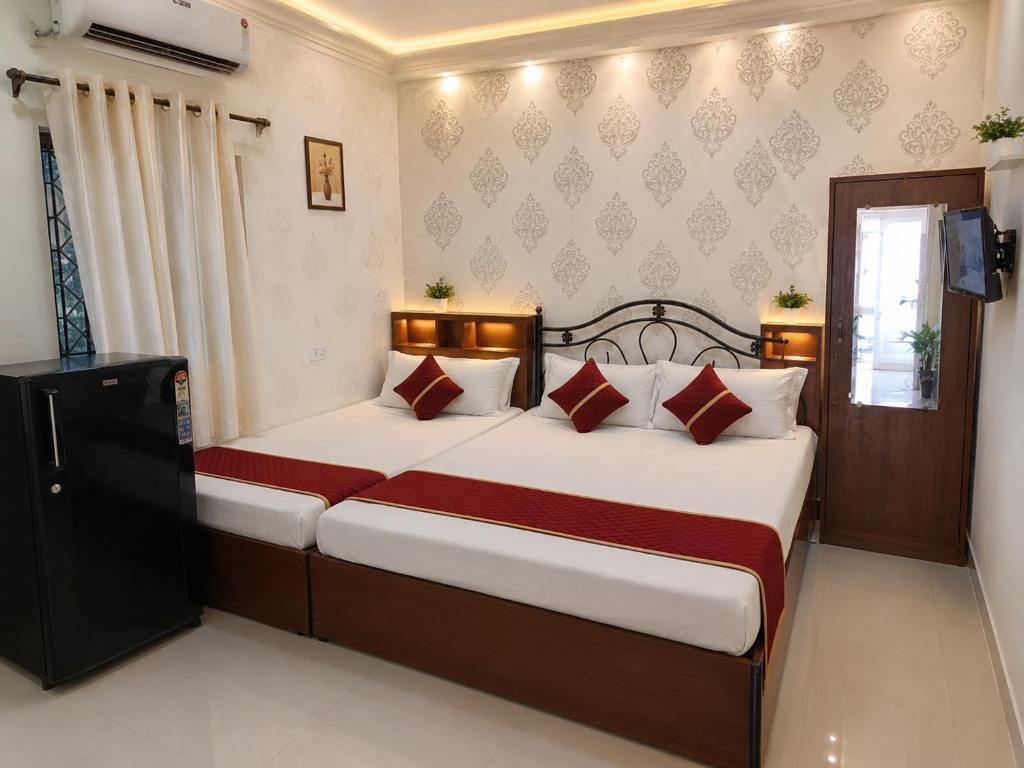 a bedroom with a large bed with red and white pillows at Calangute in Guest House in Calangute