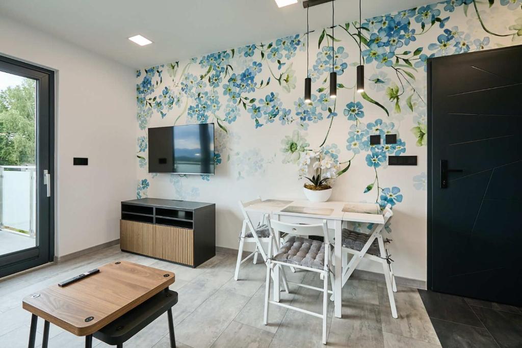 a dining room with a table and blue flowers on the wall at Apartamenty w Żywcu u Astrid in Żywiec