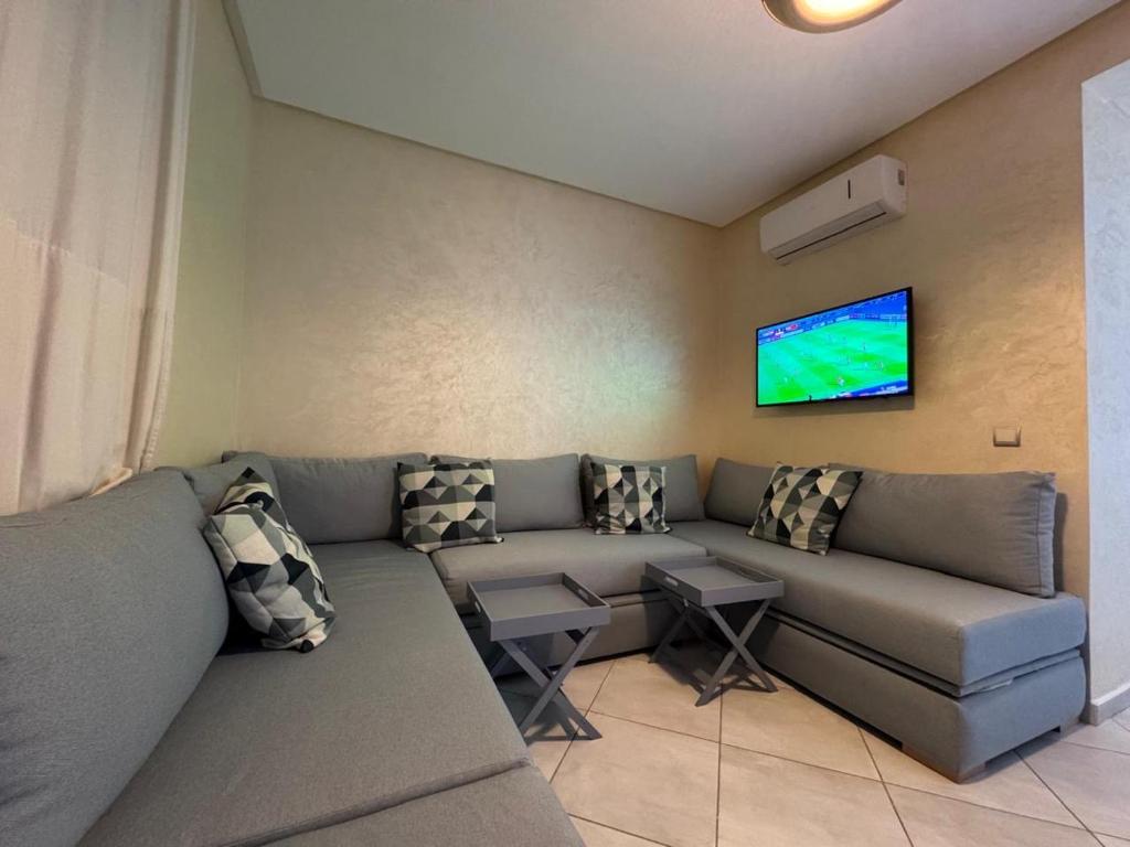 a living room with a couch and a flat screen tv at Smir Park apartamento in Marina Smir