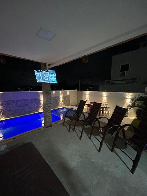 a group of chairs and a television on a house at Casa com piscima e área goutmet in Camaçari