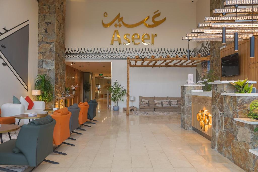 a lobby of a restaurant with orange chairs at شقق وسن الفندقية in Abha