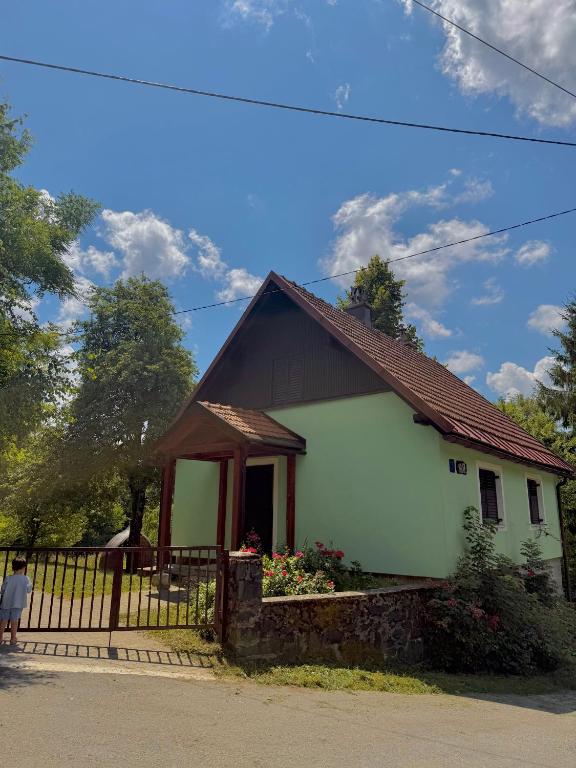 a small green and white house with a fence at FoRest Chalet in Zalesina