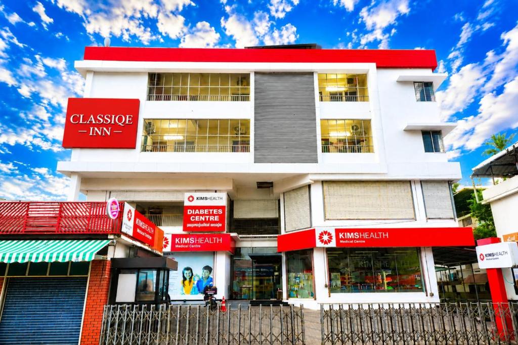 a building with red and white signs in front of it at Classique Inn Near Padmanabhaswamy Temple in Trivandrum