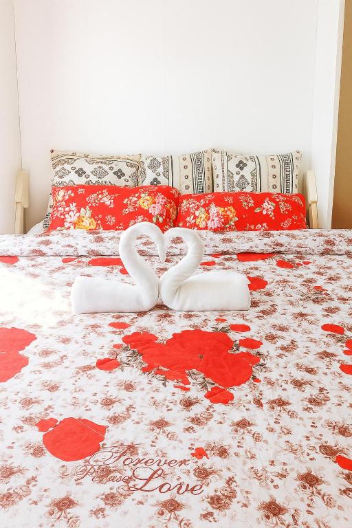 two white heart shaped towels sitting on a bed at Nice location in the persimmon condo in Cebu City