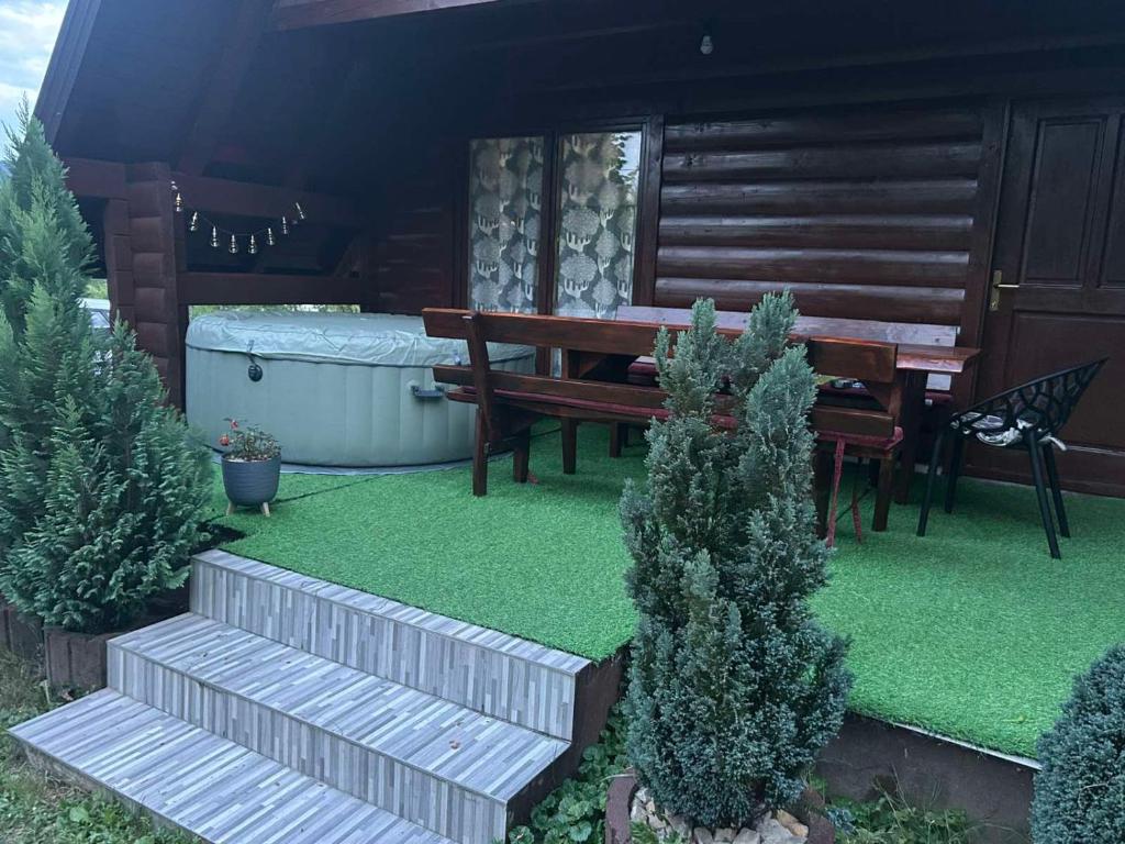 a garden with a wooden bench and a hot tub at Wooden Fairytale in Bihać
