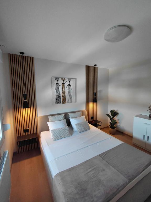 a bedroom with a large white bed with two pillows at Apartman Sandra in Varaždin