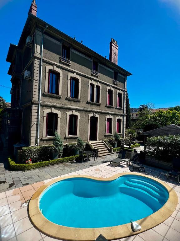 a house with a swimming pool in front of a building at La Villa de Mazamet in Mazamet