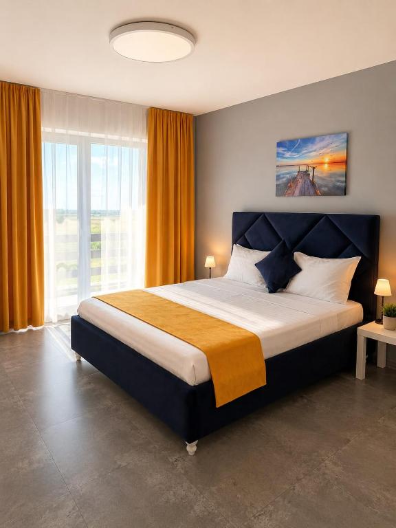 a bedroom with a large bed with a large window at Danube Delta View in Dunavăţu de Jos