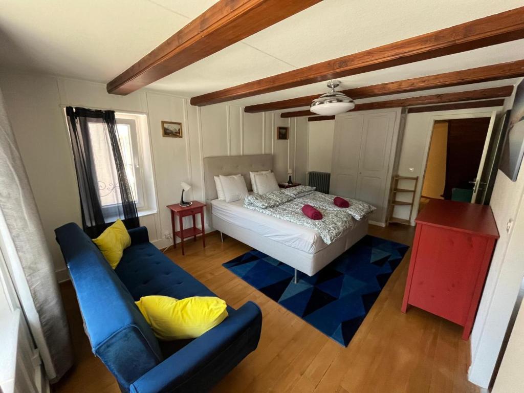 a bedroom with a bed and a blue couch at Avenue 15 Boudry Suites and Studio in Boudry