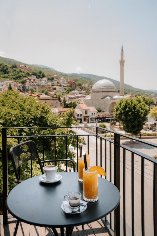 ein blauer Tisch mit zwei Getränken auf einem Balkon in der Unterkunft Monarch Boutique Hotel in Prizren