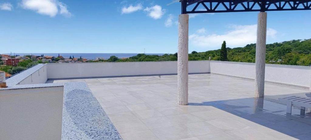 a patio with two chairs on a roof at Suite Madric in Pečurice