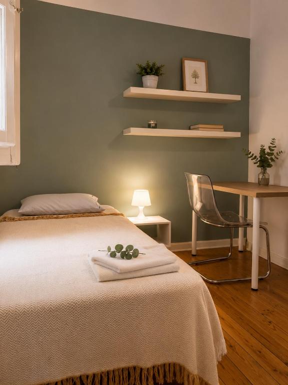 a bedroom with a bed with a table and a chair at Casa de Sta Clara in Évora