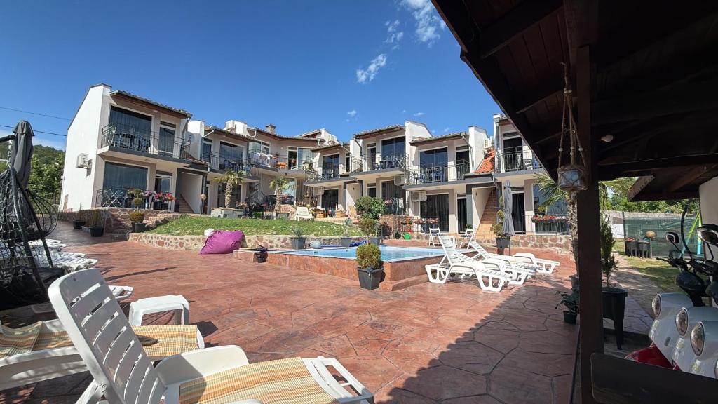 a patio with chairs and a pool and some houses at Serenity Hill-Bulharsko U Nás in Sveti Vlas