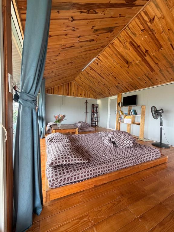 a bedroom with a large bed with a wooden ceiling at Vườn của mẹ in Da Lat