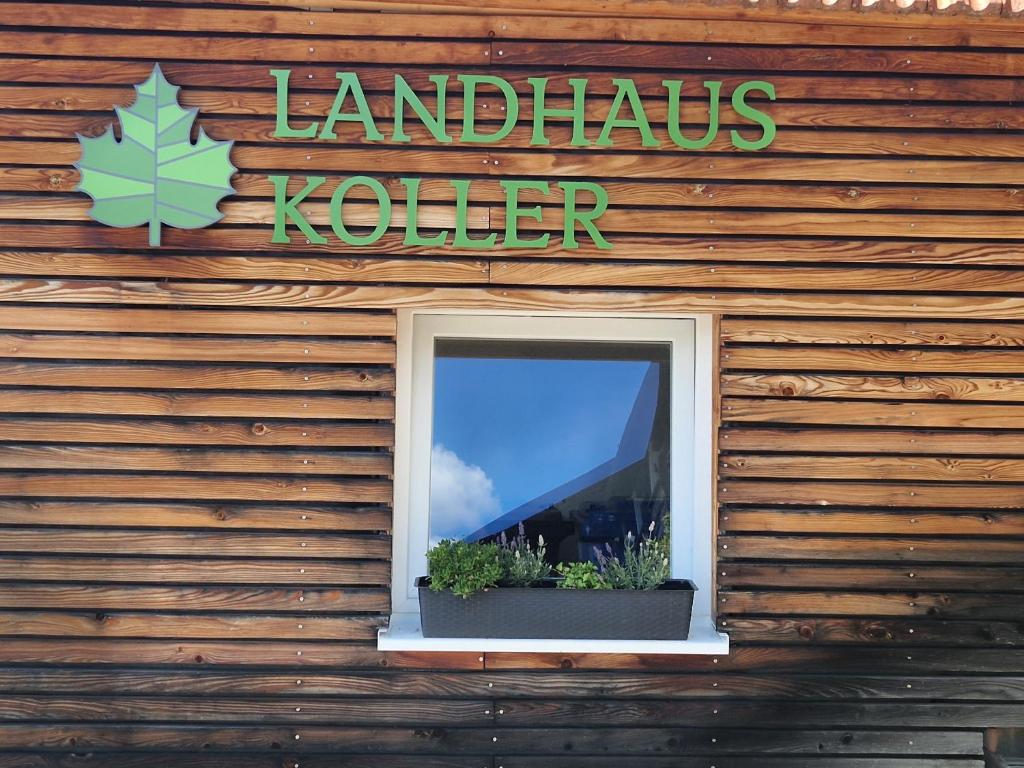a window on the side of a building with a sign at Pension Landhaus Koller - Adults only in Bodenmais