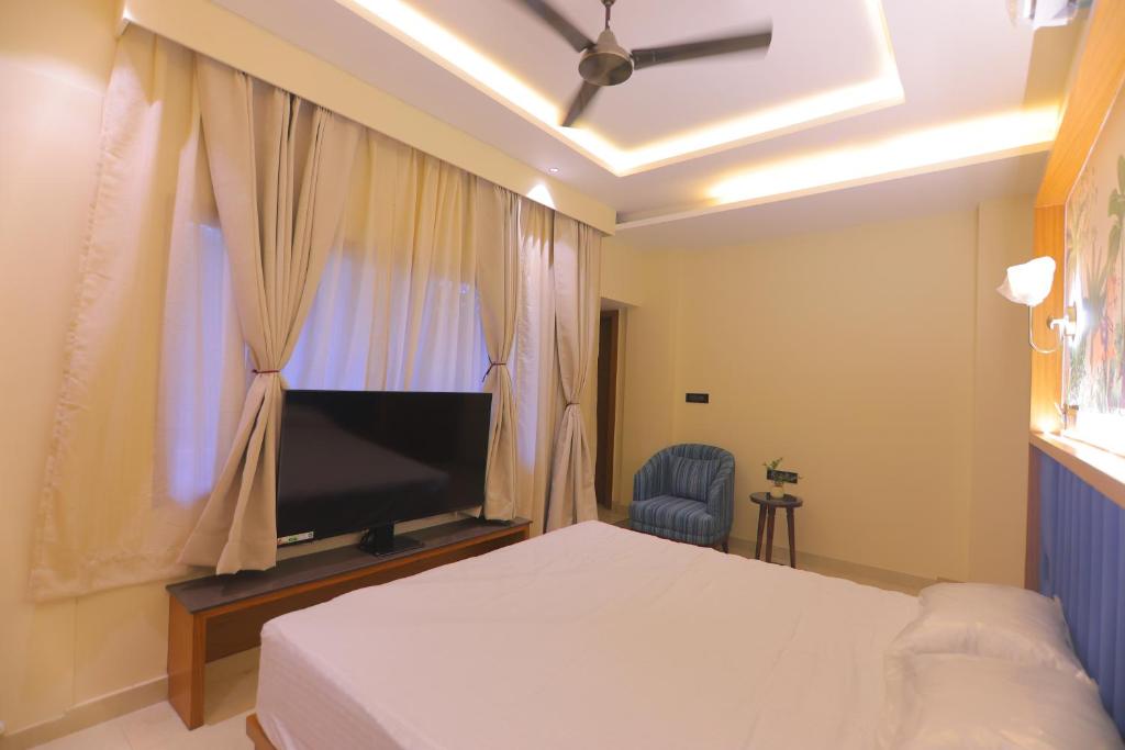a bedroom with a bed and a flat screen tv at Chunmun Elite Retreat in Bulandshahr