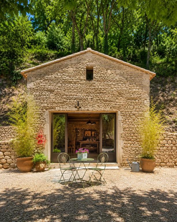 a stone building with two chairs in front of it at Atelier Provençal in La Celle-sous-Gouzon