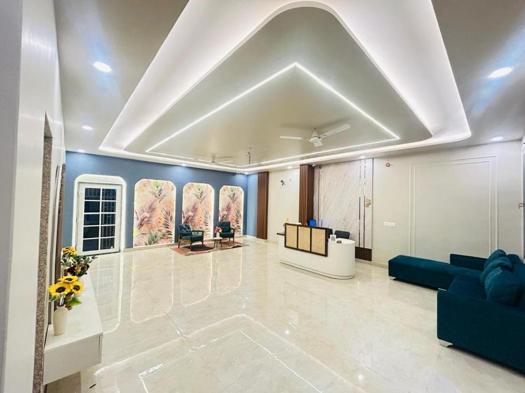 a large living room with a white ceiling and blue walls at Hotel Veda Vatica in Varanasi