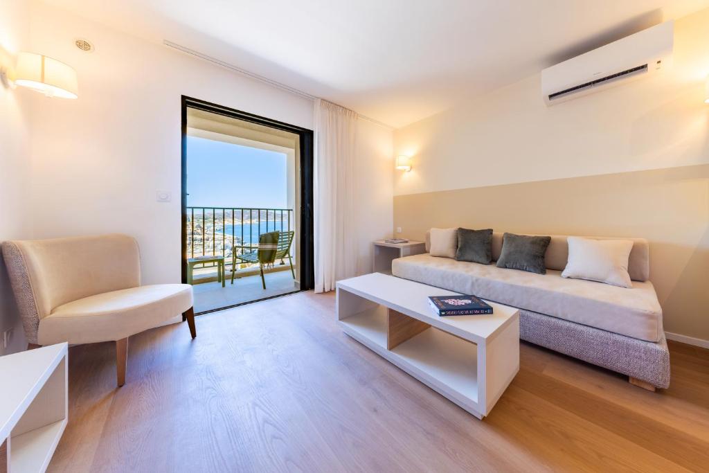 a living room with a couch and a chair at Appart'hotel Saint Francois in Calvi