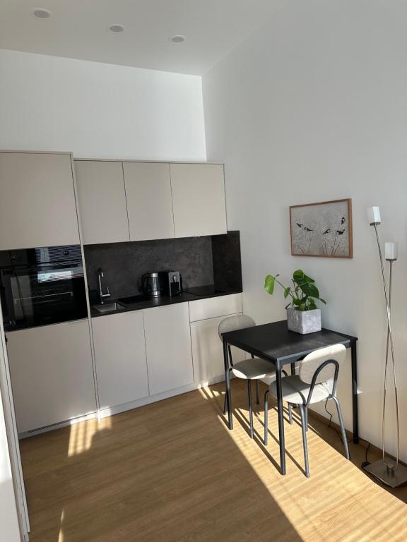 a small kitchen with a black table and chairs at Apartament Mini Stary Sącz in Stary Sącz