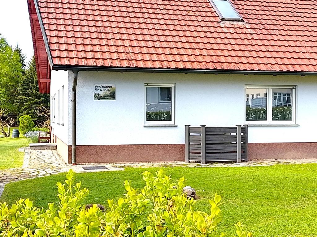 a white house with a red roof at Ferienhaus Ringelwiese in Schönstedt